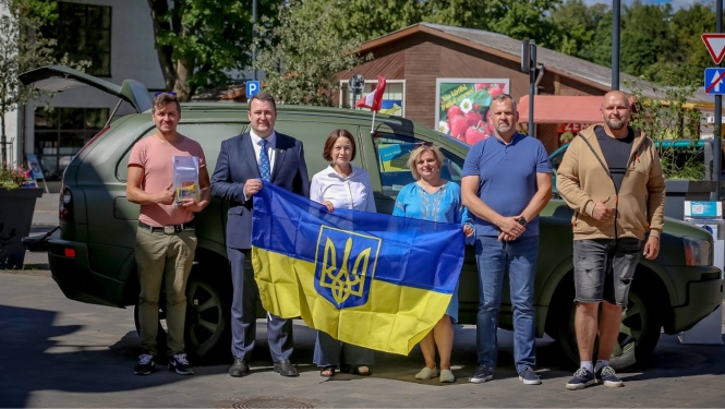 kopbilde ar Ukrainas karogu pie mašīnas, ko vedīs uz Ukrainu