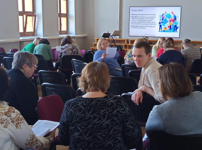 Skolotāji apspriežas auditorijā 