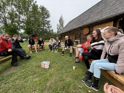 jaunieši sēz uz soliņiem aplī