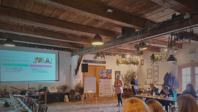 foto ar cilvēku auditorijas priekšā, kas prezentē prezentāciju 