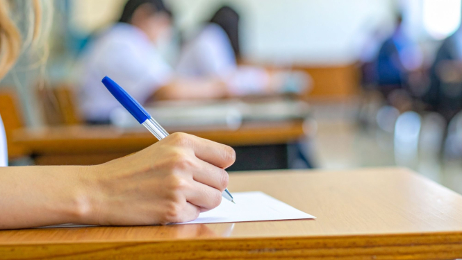 cilvēks raksta ar pildspalvu zilā krāsā