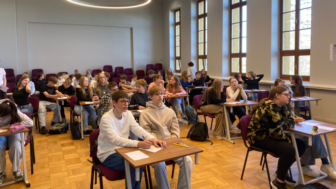 foto ar kolēnime kas sēž pie galda zālē