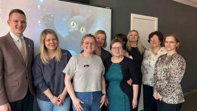 Skolotāji nostājušies rindā uz fotogrāfiju 