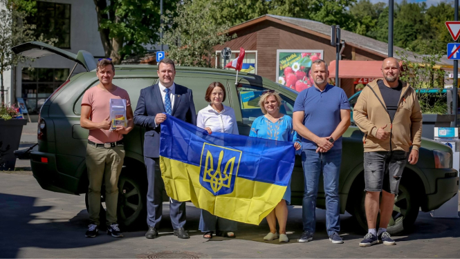 kopbilde ar Ukrainas karogu pie mašīnas, ko vedīs uz Ukrainu