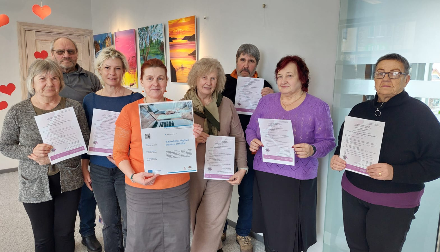 Foto ar mācību dalībniekiem, kas tur rokās savus sertifikātus